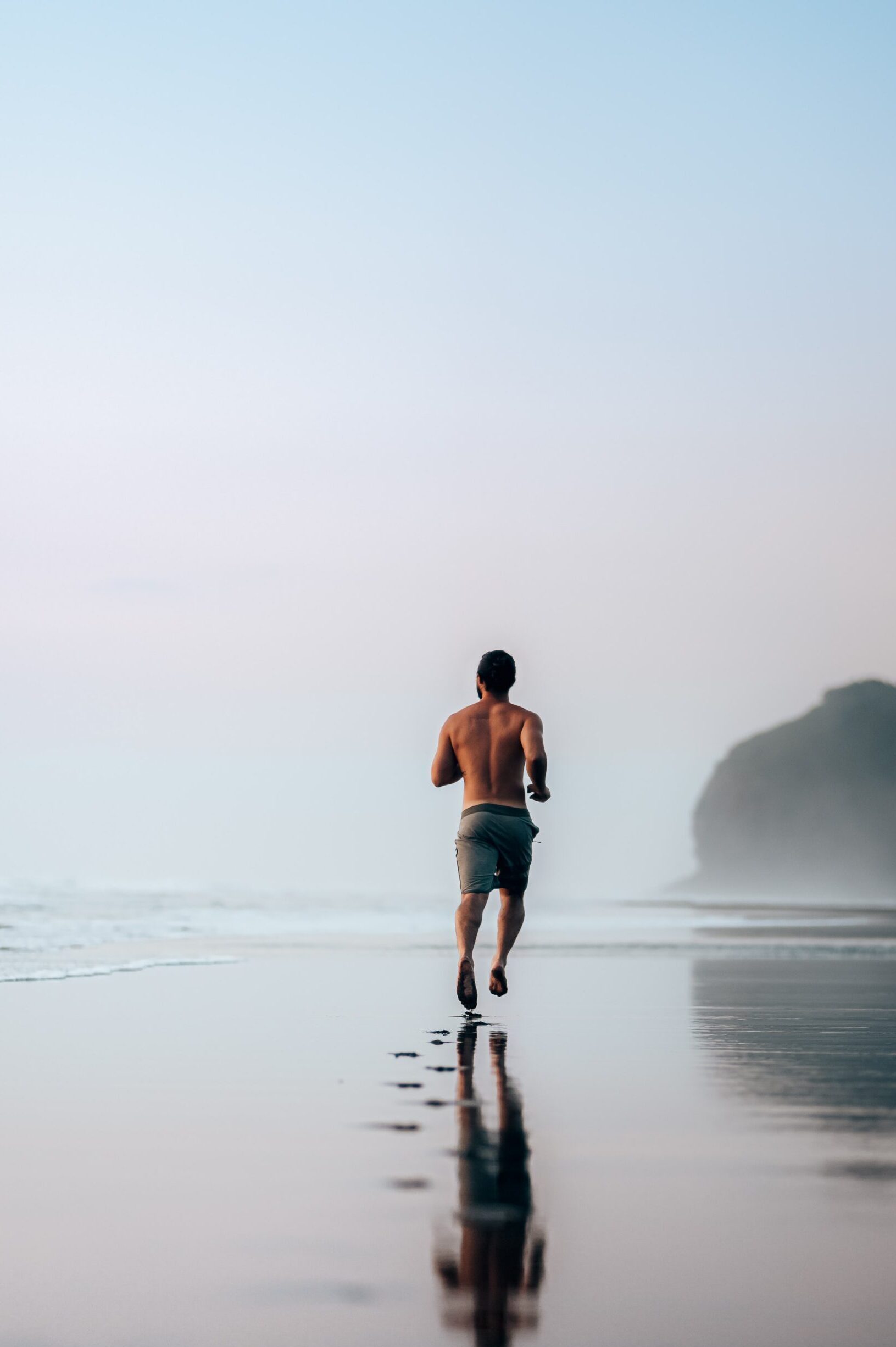 Sportlicher Mann joggt am Strand, Bild für Health Coaching in Hamburg